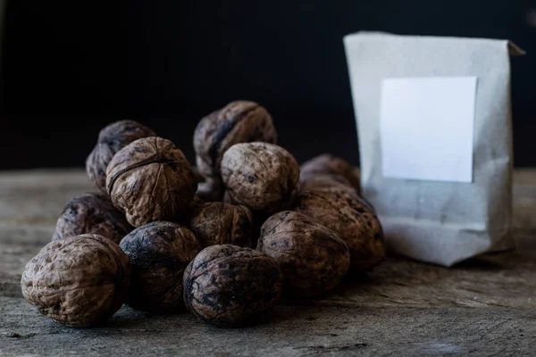 Nuts in a paper bag on the kitchen wooden table.