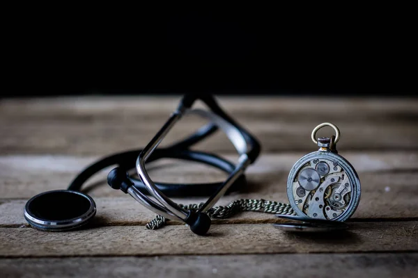 stock image Stethoscope on a wooden table. Dark background.