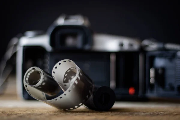 Old analog camera on a wooden table and accessories.