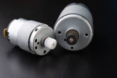 Ahşap bir karanlık tabloda küçük elektrikli motor. Küçük ev aletleri için elektrikli sürücü. Koyu arka plan.
