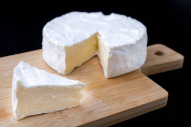 Lezzetli mavi peynir bir ahşap tahta üzerinde. İtalyan yemekleri mutfak masasında hazır. Koyu arka plan.