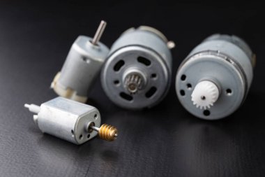 Ahşap bir karanlık tabloda küçük elektrikli motor. Küçük ev aletleri için elektrikli sürücü. Koyu arka plan.