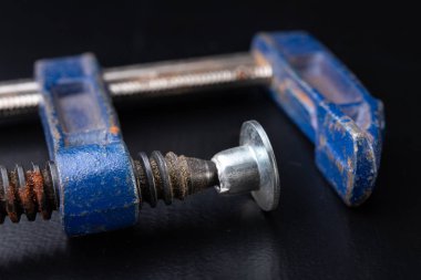 Eski bir doğrama Atölyesi masaya kelepçe. Marangozlar için aksesuarlar. Koyu arka plan.