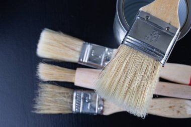 Fırçalar için boyama boya ve kutular ile bir atölye tablo. Boyama için hazırlanmış boyama aksesuarları. Koyu arka plan.