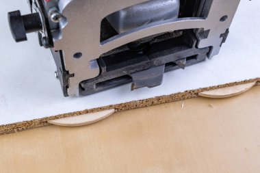 Sanayi sipes ve özel freze makinesi kullanarak atölyesinde çalışıyor. Açık renkli.