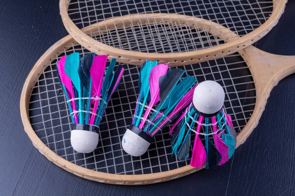 Colorful feathers in the badminton shuttlecock. Team play set. Dark background.