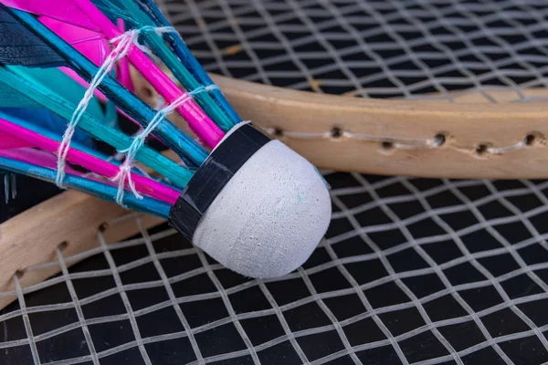 Colorful feathers in the badminton shuttlecock. Team play set. Dark background.