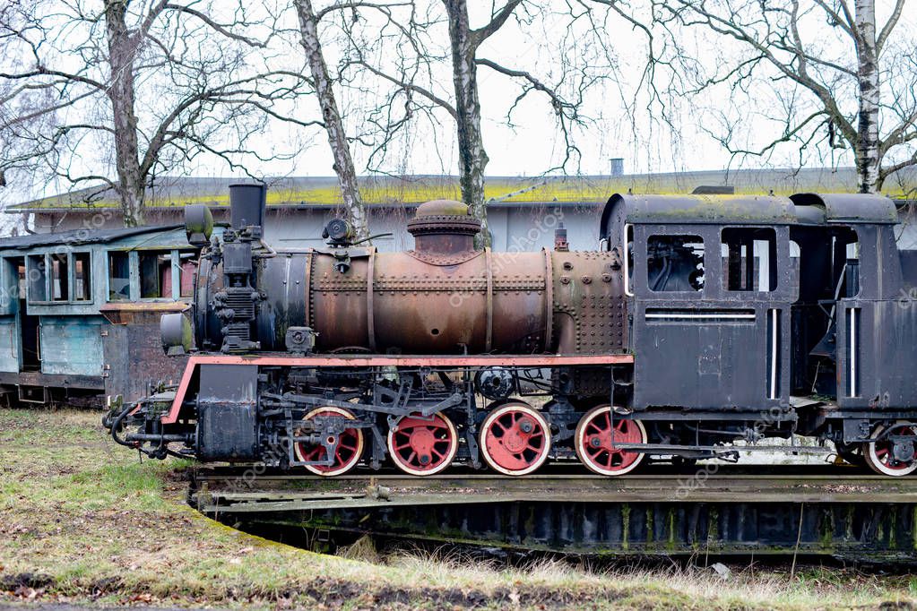 Old rusty locomotive of the narrow gauge railway. Place of stati