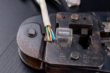 Elektronikte kullanılan bağlantıları üzerine bir atölye çalışması. Bilgisayar kablo ve konektörleri rj44. Koyu arka plan.