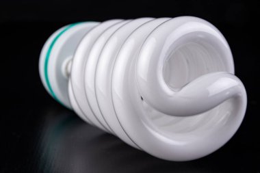 Farklı Işık Ampüller ve ahşap bir masa floresan ışıkları. Aydınlatma yeni tip. Koyu arka plan.