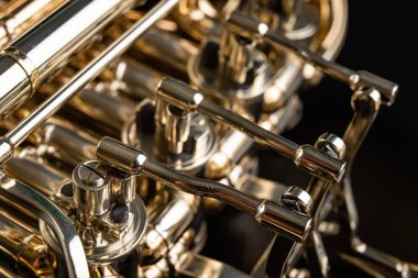 Ahşap bir masa üzerinde Fransız kornosu. Güzel cilalı müzik aleti. Koyu arka plan.