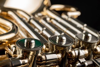 Ahşap bir masa üzerinde Fransız kornosu. Güzel cilalı müzik aleti. Koyu arka plan.