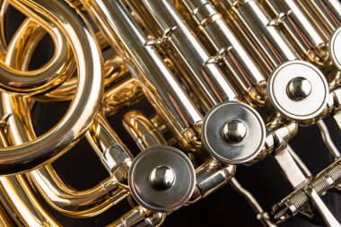 Ahşap bir masa üzerinde Fransız kornosu. Güzel cilalı müzik aleti. Koyu arka plan.