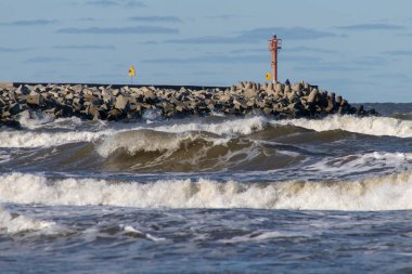 Breakwater in the port of Central Europe. Strengthening against the power of sea waves. Season winter. clipart