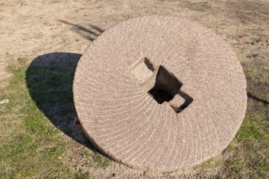 Tahıl öğütme için taş bir tekerlek. Eski değirmen öğütücüler. Yer - yerel bir kasabada bir anıt. Kış sezon.