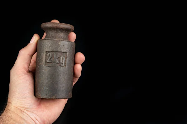 Peso metálico oxidado viejo para pesar productos en la palma de su mano — Foto de Stock