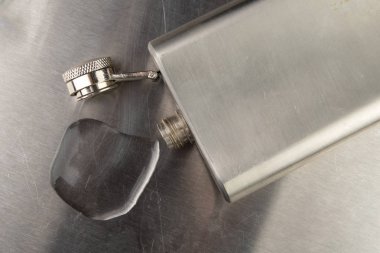 Bir bardak saf Soğuk votka. Metal meme ve dökülen alkol 