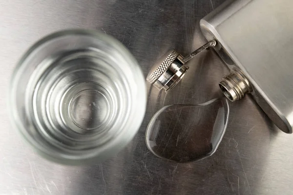 Zuivere koude wodka in een glas. Metalen borst- en gemorste alcohol op — Stockfoto