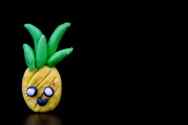 Hamuru figürler koyu ahşap bir masa üzerinde. İmitasyon pineap