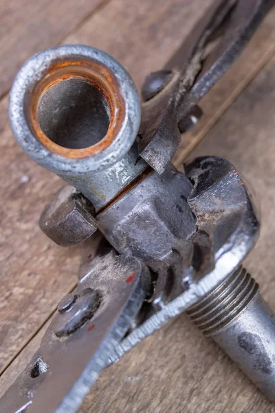 Chiave idraulica e tubi in acciaio su un tavolo da officina. Meccanismo minore — Foto Stock