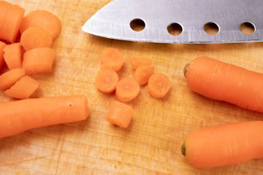 Küçük havuç ahşap bir gemide bir bıçak ile kesmek. Sebze öncesi