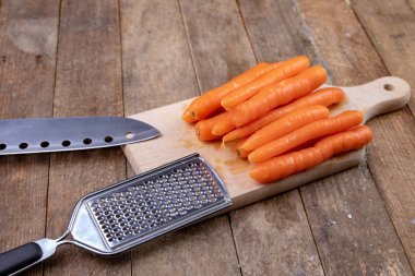 Mutfak masasının üstünde küçük havuç rendesi. İçin hazırlanan sebzeler