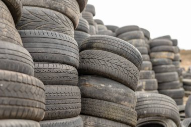 Eski lastikler bir terk edilmiş çöp dökümü üzerinde yıpranmış. Çöp yığını okuyun