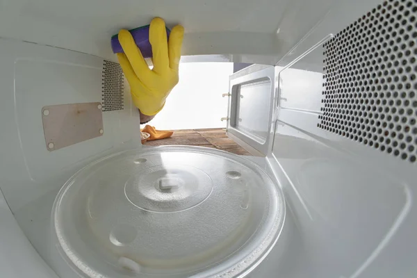 Cleaning the inside of the microwave in the home kitchen. The de — Stock Photo, Image
