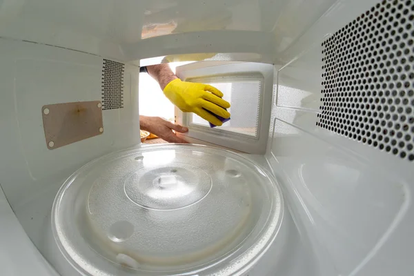 Уборка внутри микроволновки на домашней кухне. The de — стоковое фото