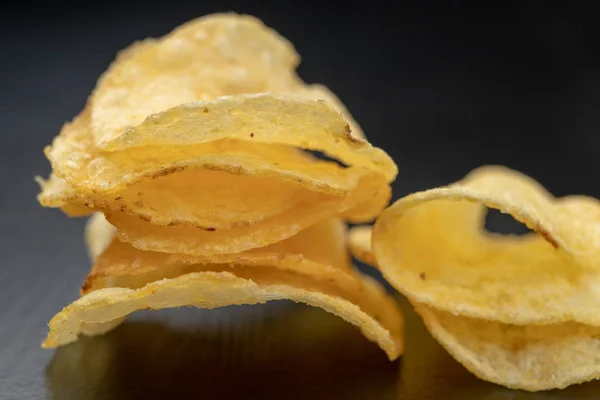 Tasty crisps on the kitchen table. Salty snacks as an addition t — Stock Photo, Image