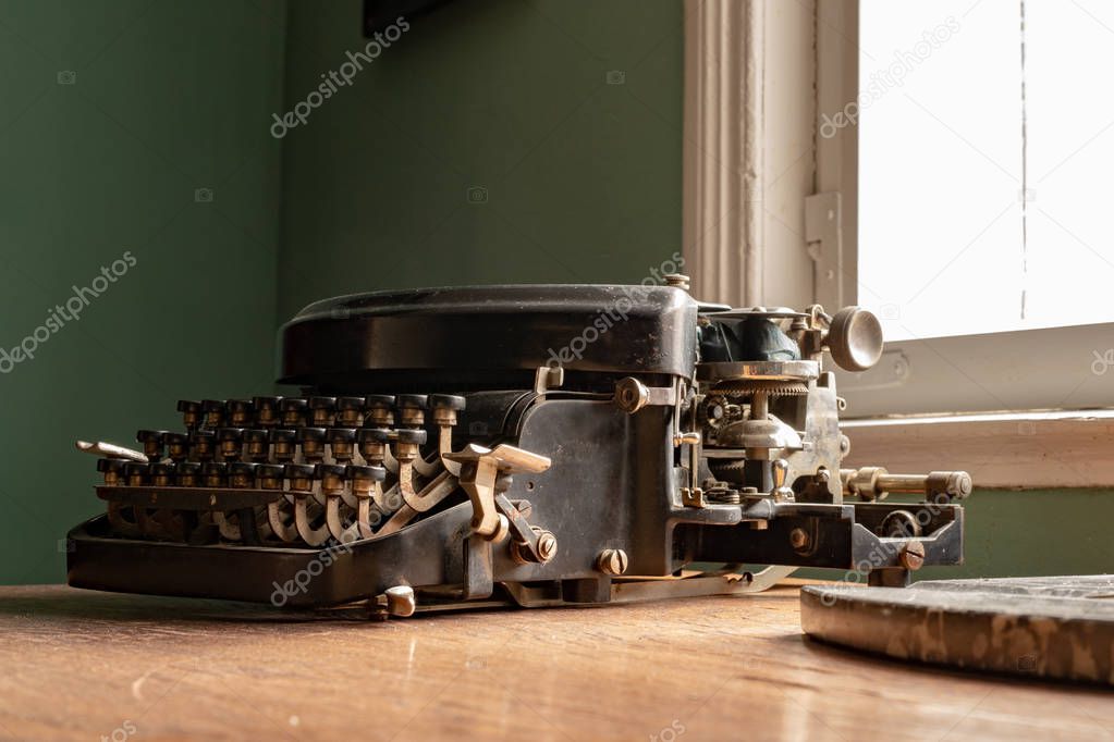 An old typewriter on a desk in a household. Accessories for writ