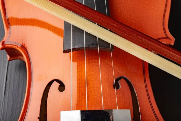 Beautiful new shiny violin on a dark table. Musical string instr — Stock Photo, Image