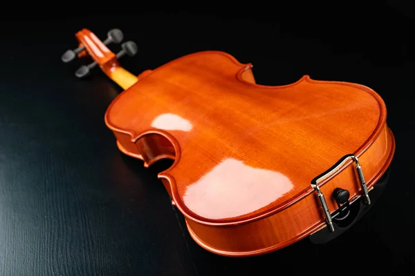 Beautiful new shiny violin on a dark table. Musical string instr