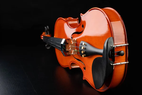 Beautiful new shiny violin on a dark table. Musical string instr — Stock Photo, Image