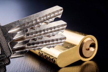 Karanlık bir arka planda yeni bir kapı kilidi. Bir patent ve anahtarları SECUR
