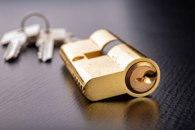 Karanlık bir arka planda yeni bir kapı kilidi. Bir patent ve anahtarları SECUR