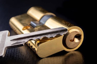 Karanlık bir arka planda yeni bir kapı kilidi. Bir patent ve anahtarları SECUR