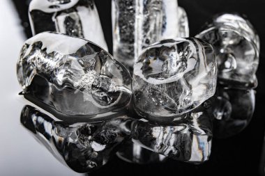 Siyah bir masada tüp şeklinde buz. Mutfakta erimiş buz küpü