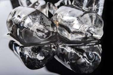 Siyah bir masada tüp şeklinde buz. Mutfakta erimiş buz küpü