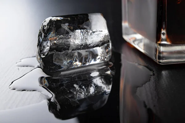 Hielo en forma de tubo sobre una mesa negra. Cubo de hielo derretido en la cocina —  Fotos de Stock