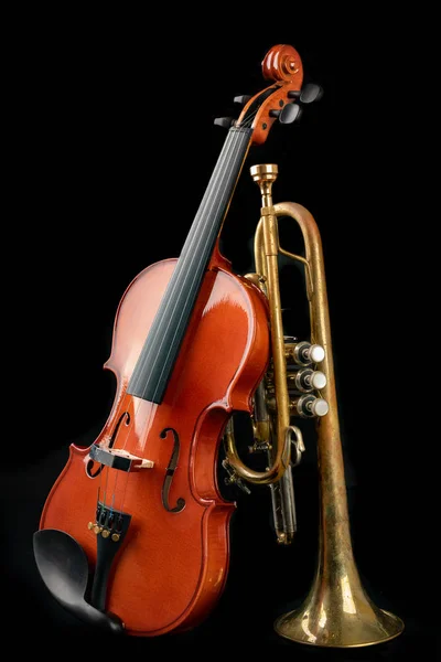 Un nuevo violín brillante y una vieja trompeta en una mesa oscura. Musical — Foto de Stock