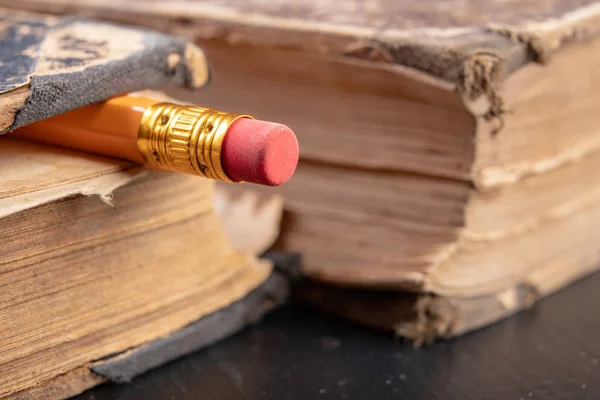 Gumka związana z ołówkiem i starą książką. Akcesoria do pisania — Zdjęcie stockowe