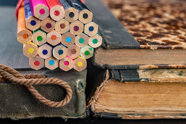 Barevné tužky na staré knize. Knihy ve starých krycích a barvotvorcích — Stock fotografie