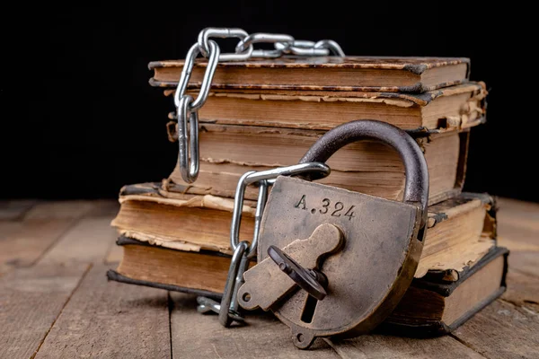 Oude boeken gebonden door een nieuwe glanzende ketting met een oud hangslot. Verbieden — Stockfoto