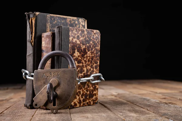 Oude boeken gebonden door een nieuwe glanzende ketting met een oud hangslot. Verbieden — Stockfoto