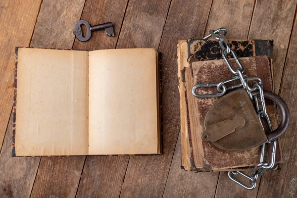 Libros viejos atados por una nueva cadena brillante con un viejo candado. Prohibido. — Foto de Stock