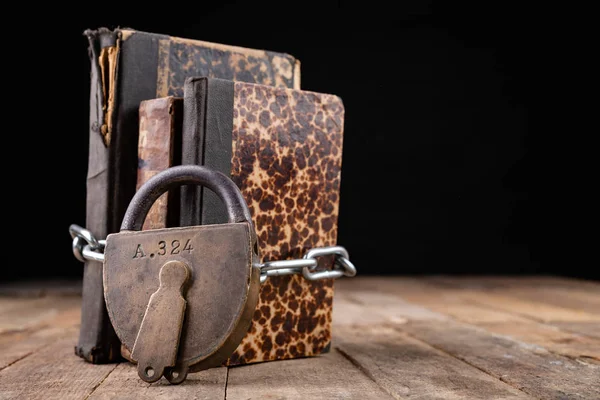 Oude boeken gebonden door een nieuwe glanzende ketting met een oud hangslot. Verbieden — Stockfoto