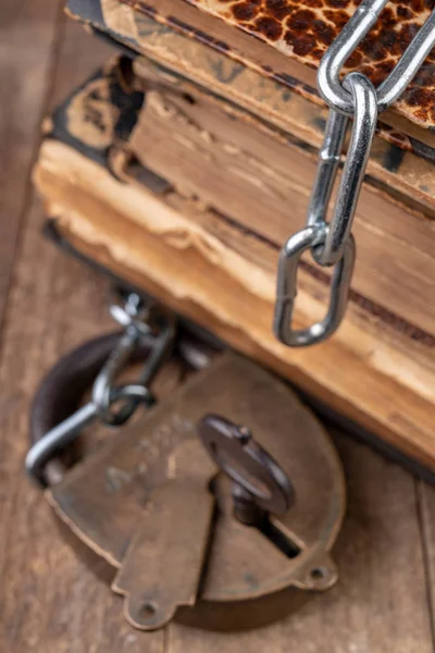 Oude boeken gebonden door een nieuwe glanzende ketting met een oud hangslot. Verbieden — Stockfoto