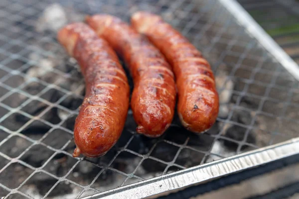 Roast sausage on the grill. Preparing a meal on a camping. — Stock Photo, Image
