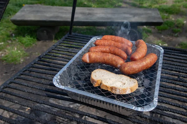 Stek korv på grillen. Förbereda en måltid på en Camping. — Stockfoto